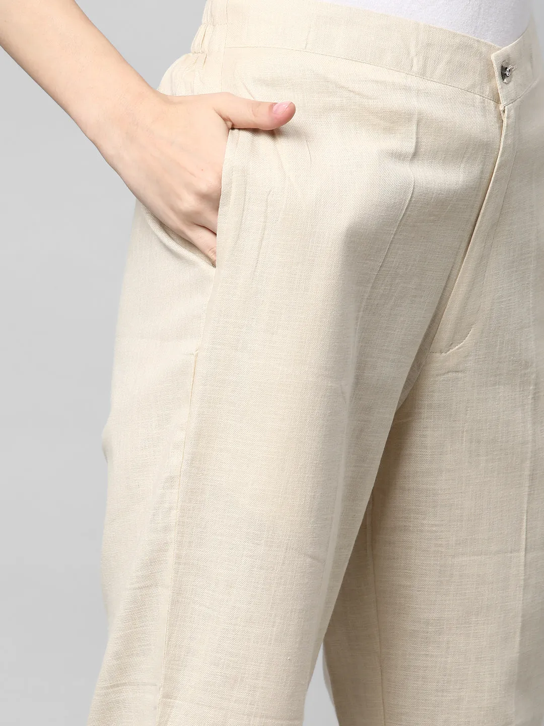 A Cream ankle length cotton linen pant with plain belt in front.